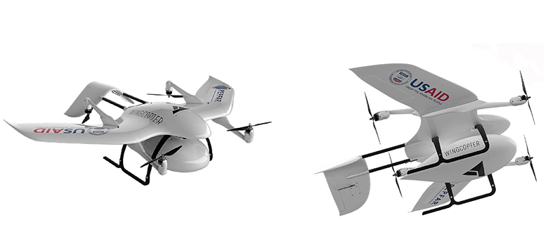 Two unmanned aerial vehicles emblazoned with the USAID and Wingcopter logos