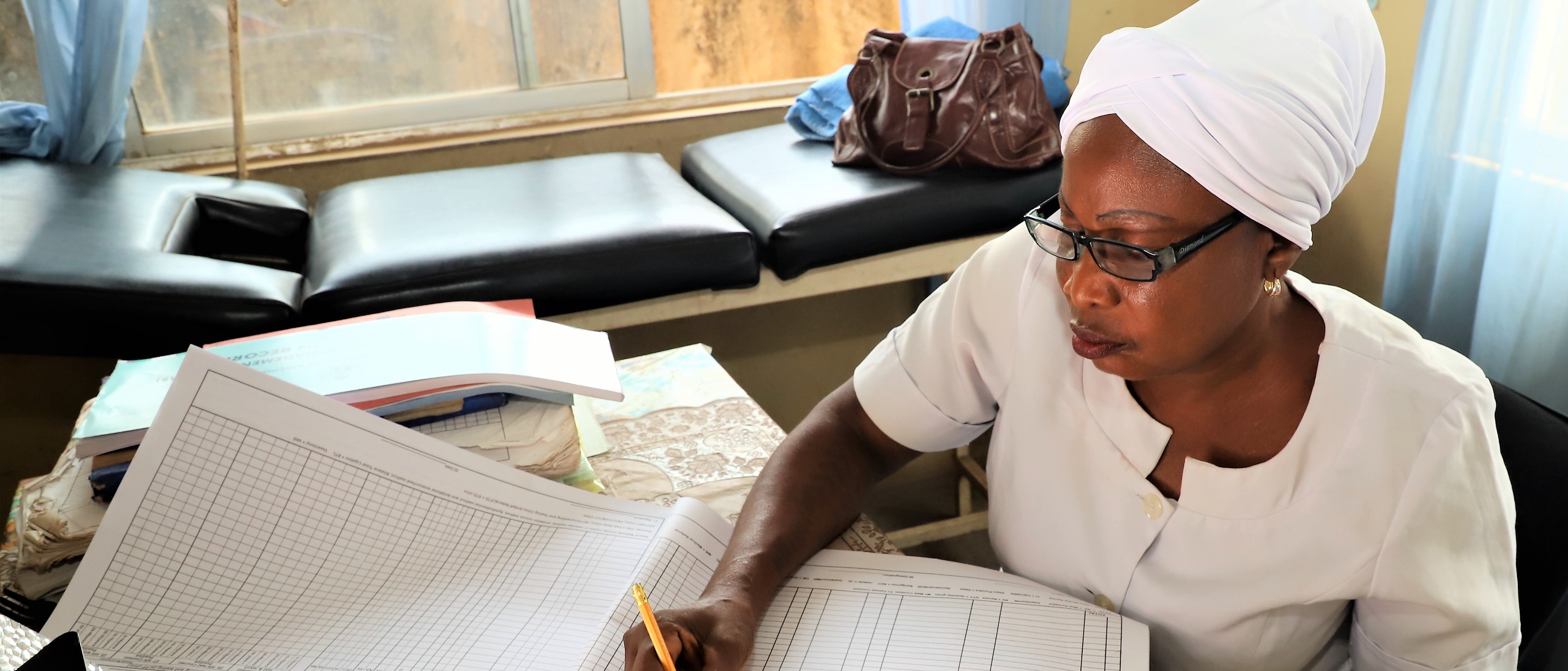 Nurse Anike fills out a family planning register at Apata health facility in Nigeria
