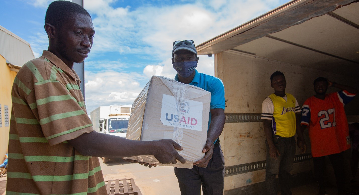 supply chain workers unload boxes of health commodities from truck