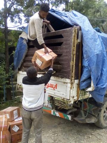 men loading boxes of old HIV treatment medicines onto the truck