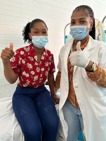 Secia with healthcare worker both giving a thumbs up