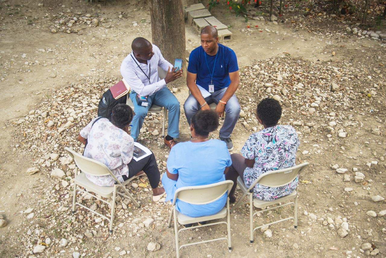 Evens Civil, GHSC-PSM data manager, teaches health workers how to use the Smartphone for Reporting app for improved supply planning.