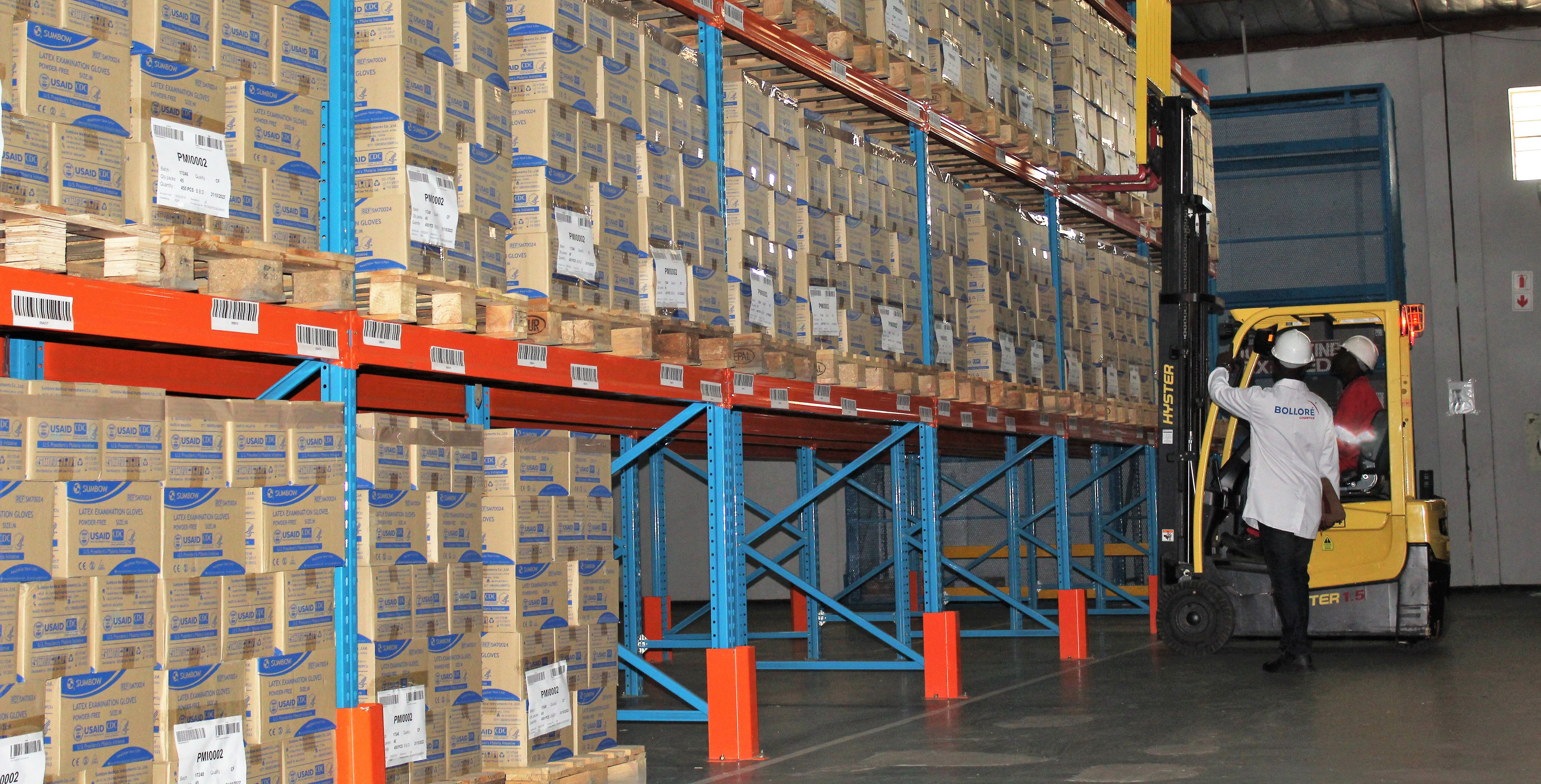 men and forklift in large warehouse