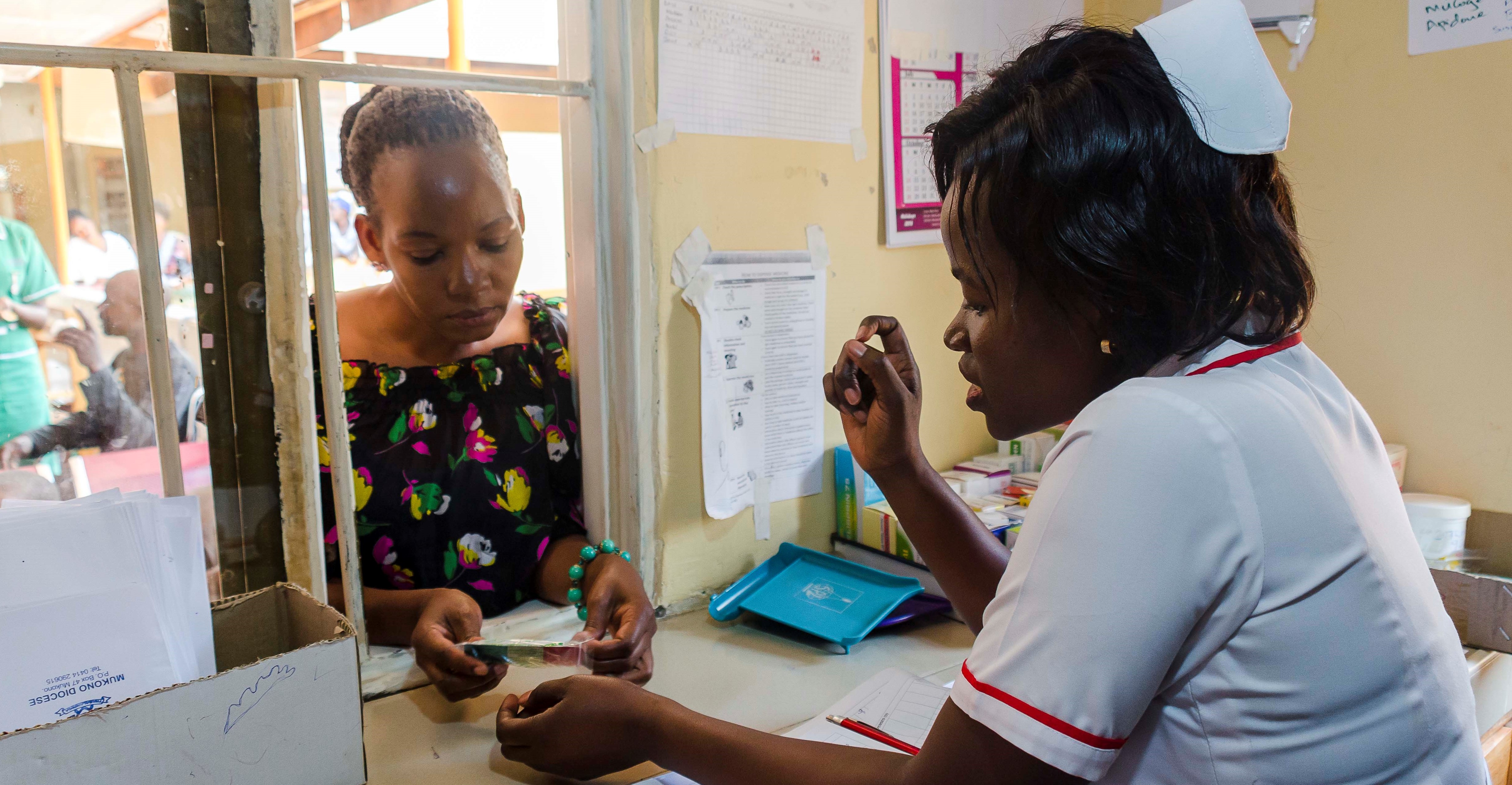 pharmacist counsels patient on medication at pharmacy window