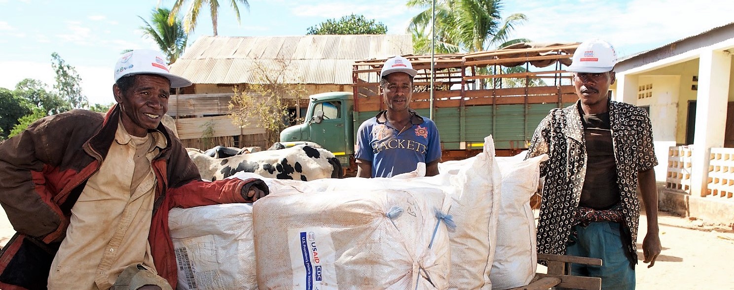 Malagasy men load malaria bed nets onto a cart in preparation for distribution.