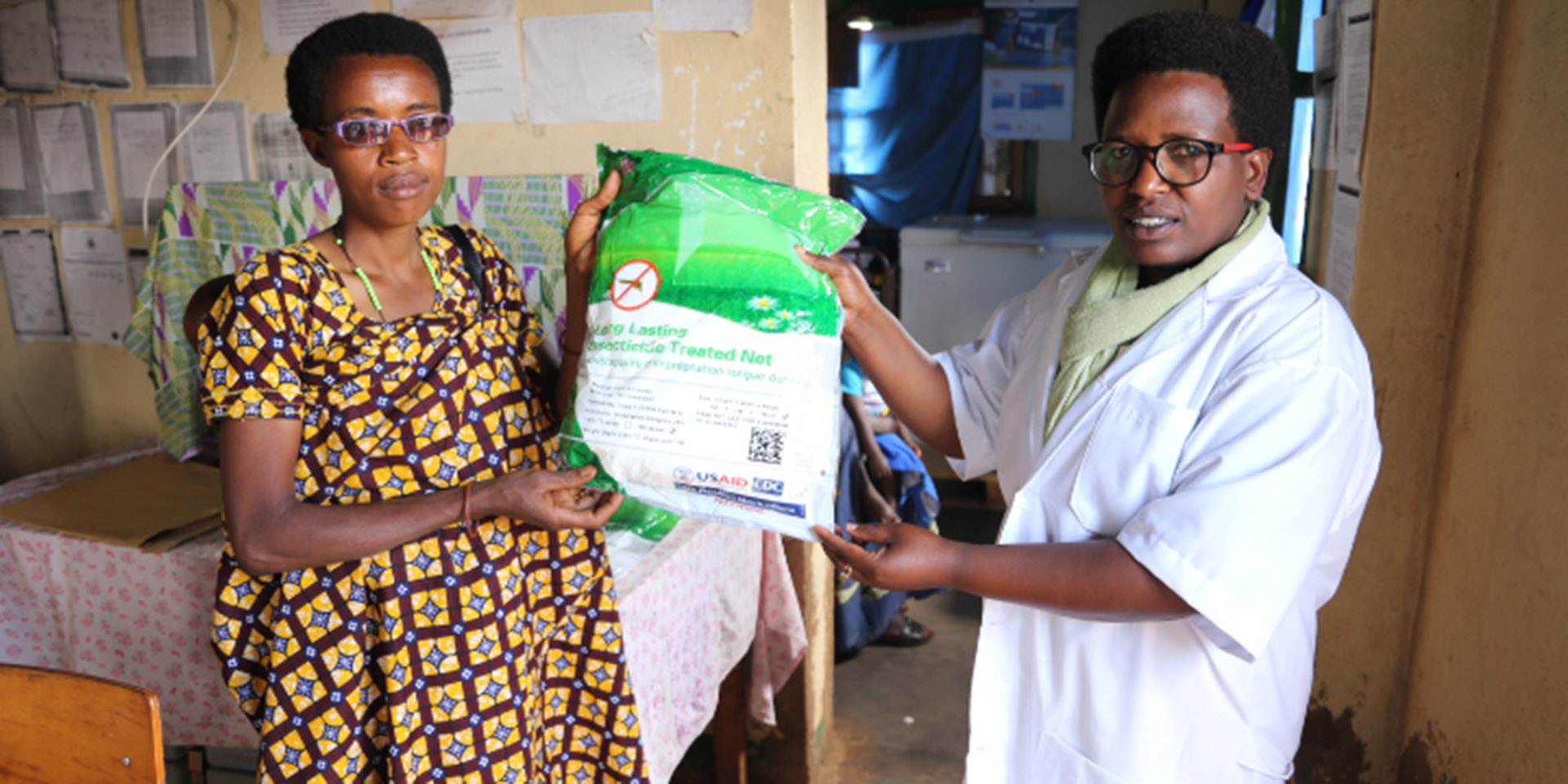 A pregnant woman receiving an insecticide-treated mosquito net after antenatal care at Kibumbu health center, Mwaro province.