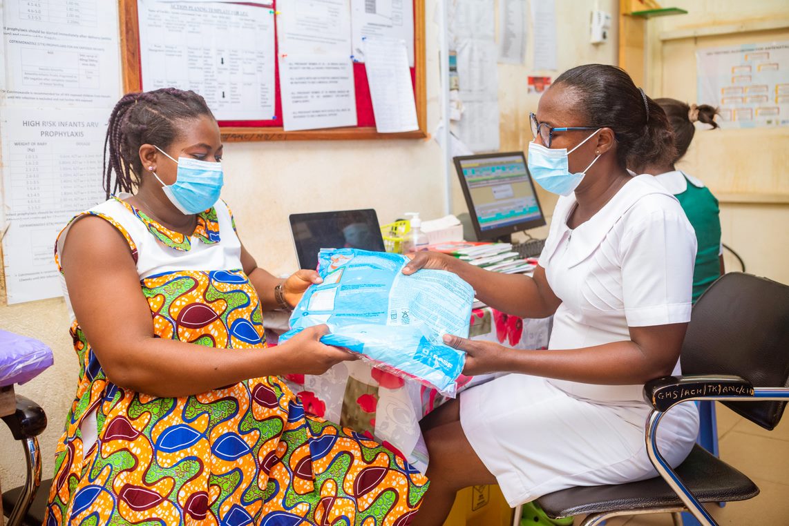 Nurse at Teberebie Health Centre hands over LLINs to client