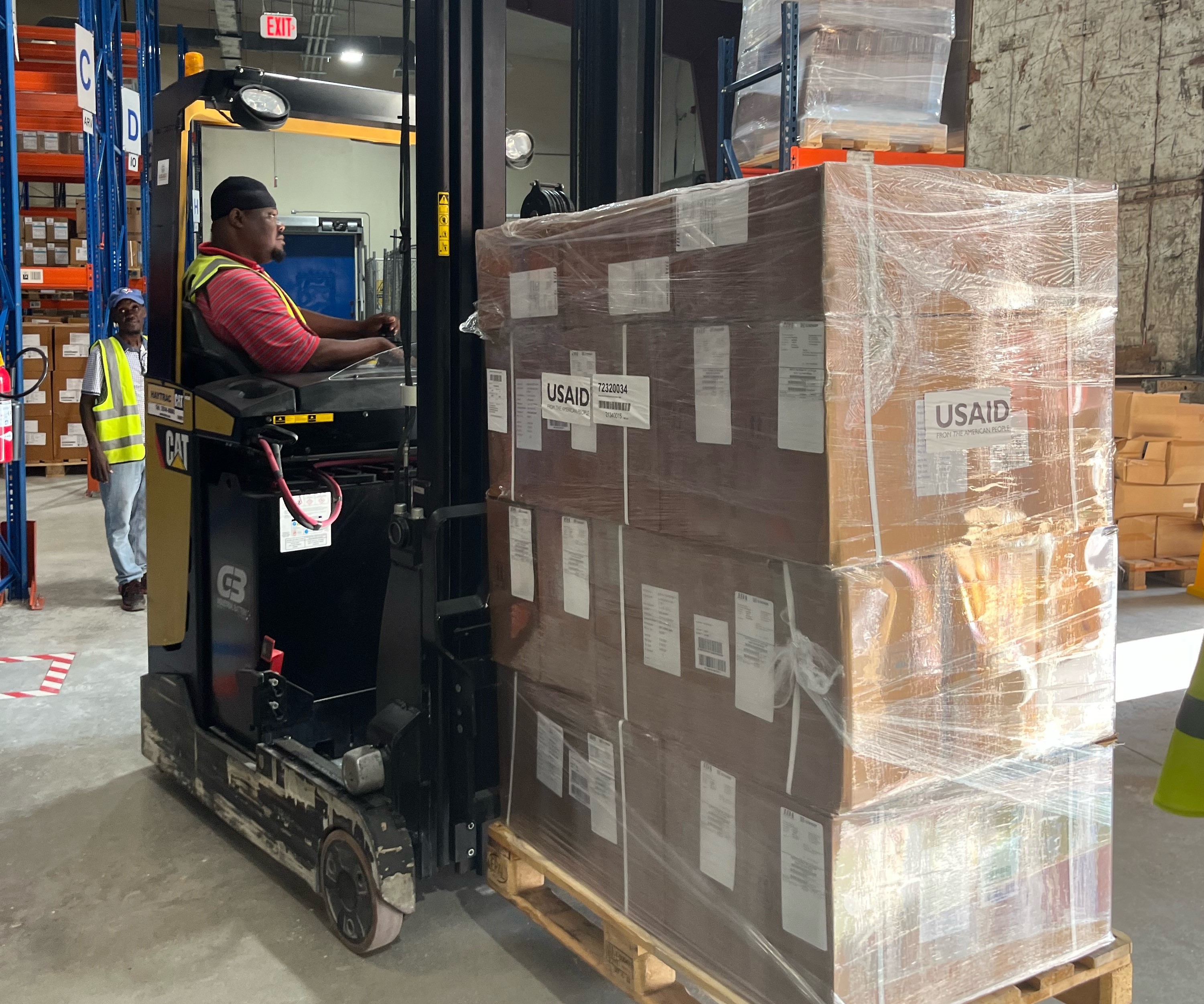 warehouse worker moves pallets with machine