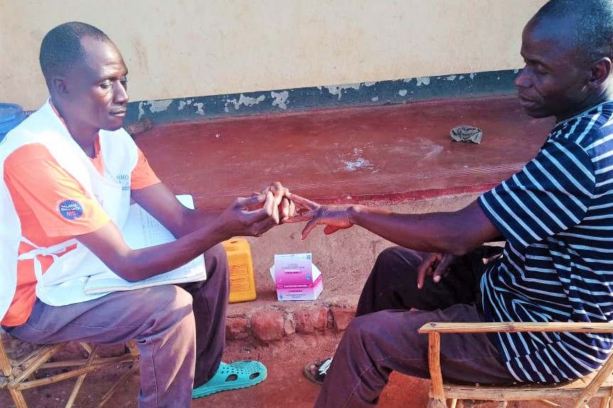 Christopher Phiri attending to a member of his community