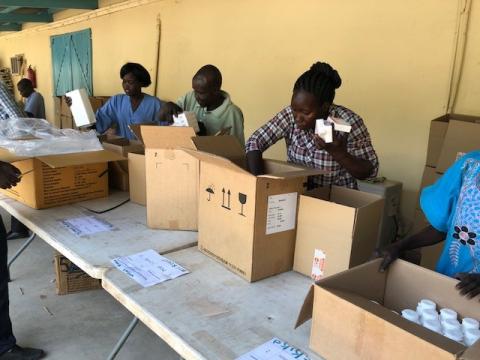 Workers pack commodities into kits for distribution to health facilities. Photo Credit: GHSC-PSM